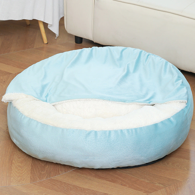 Light blue cave dog bed profile view — soft velvet exterior and plush interior visible